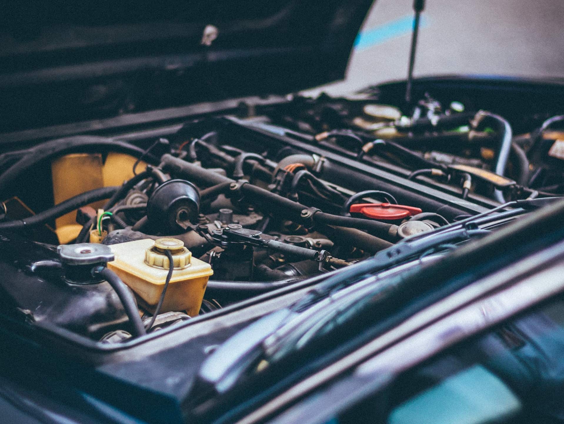 Nahaufnahme eines geöffneten Automotors mit verschiedenen sichtbaren Motorteilen und Verkabelungen